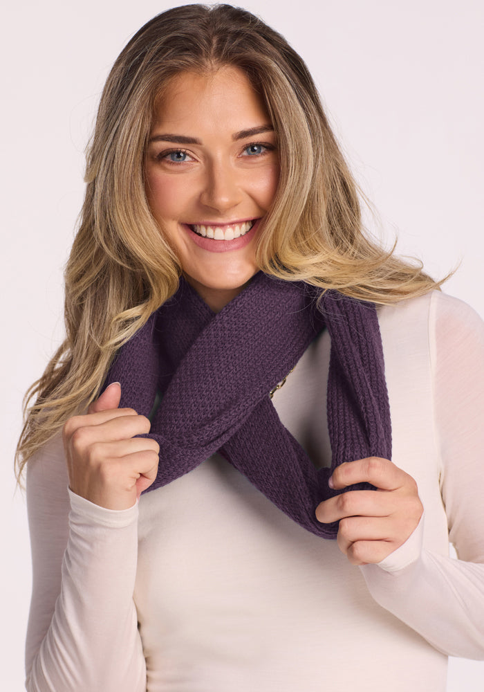Smiling woman in a white top wraps a Woolx Noelle Infinity Scarf - Purple Iris around her neck.
