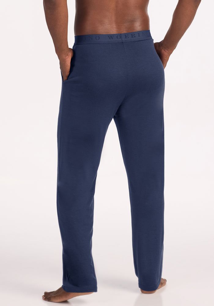 A person seen from behind wearing dark blue Woolx Arlo Lounge Pants - Deep Dive with a wide branded elastic waistband.