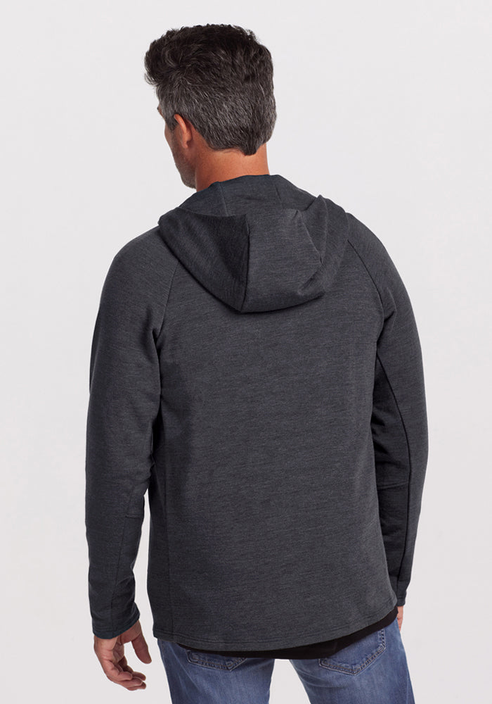 Man wears Woolx Boulder Hoodie in Cinder Melange and jeans, standing with his back to the camera against a plain background.