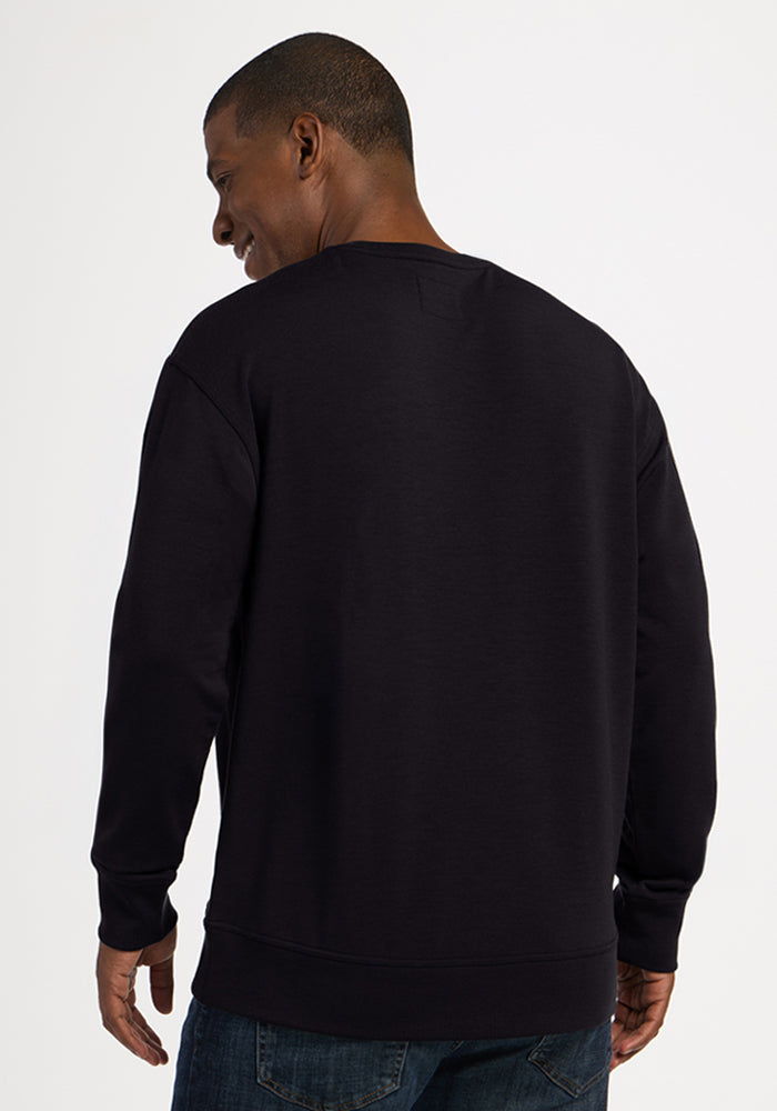 A man seen from behind wearing a black Woolx Miles Crewneck - Black sweater.
