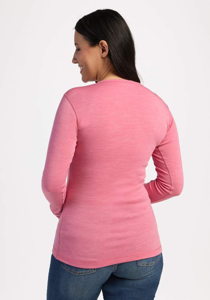 Woman facing away in Woolx Hannah Long Sleeve Top - Pinky Promise, smiling in blue jeans on white background.