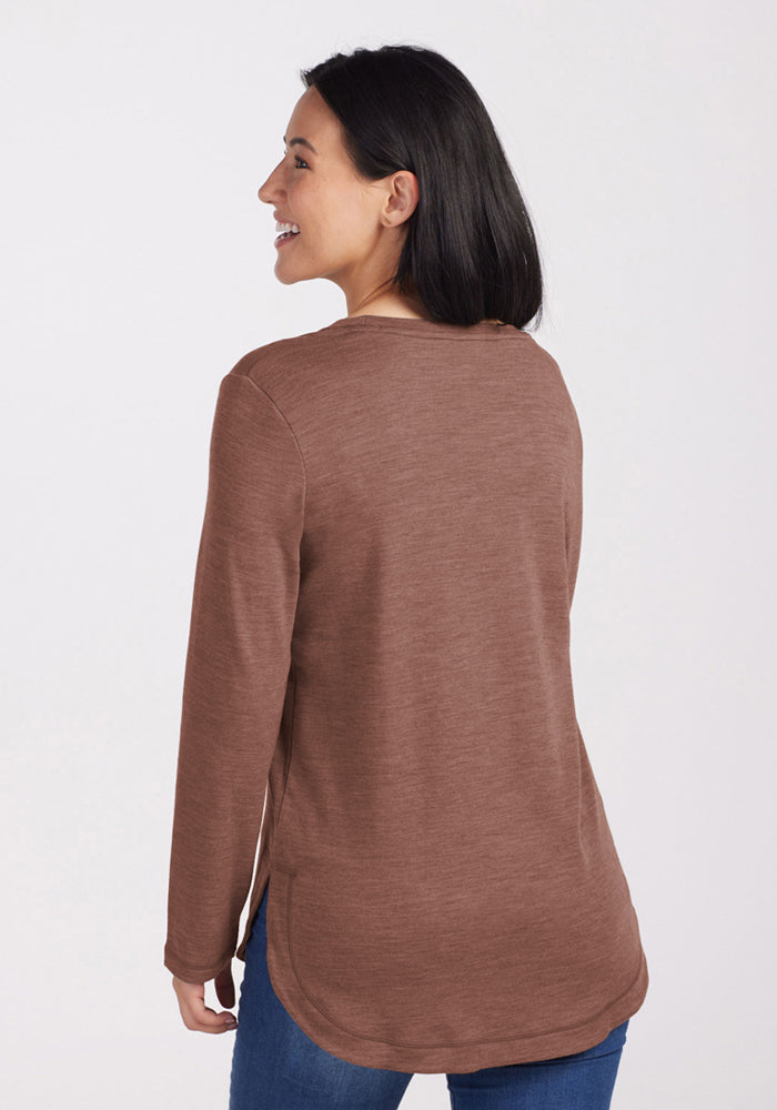 Woman smiling, facing away, in a Woolx Blair Tunic - Sable Heather—versatile, odor-resistant travel top with blue jeans.