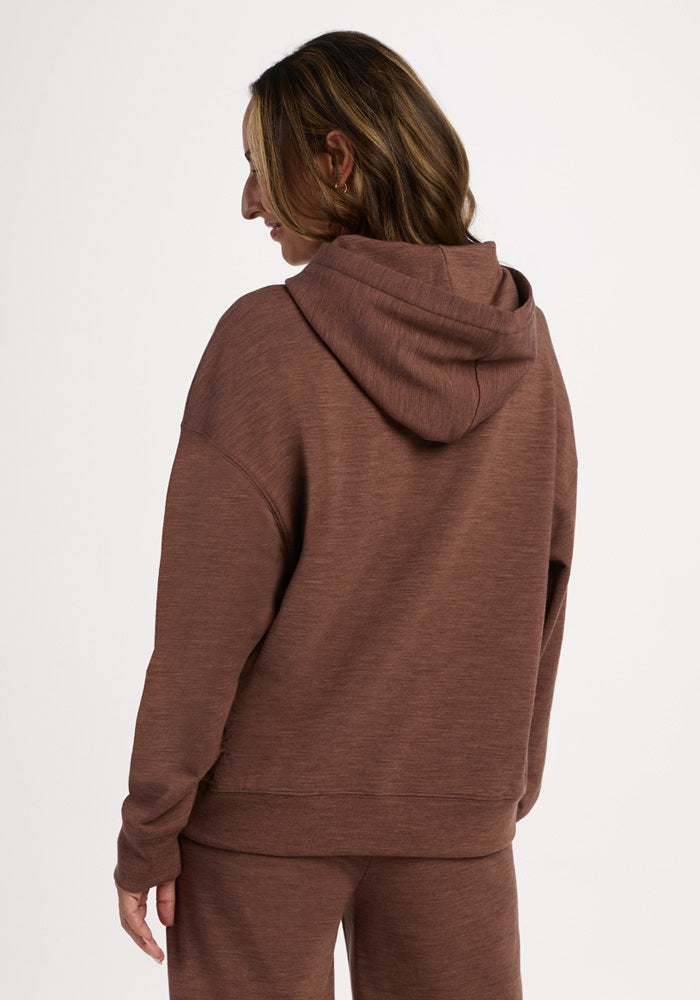 A person seen from behind wearing a brown Genevieve Hoodie - Sable Heather and matching pants.