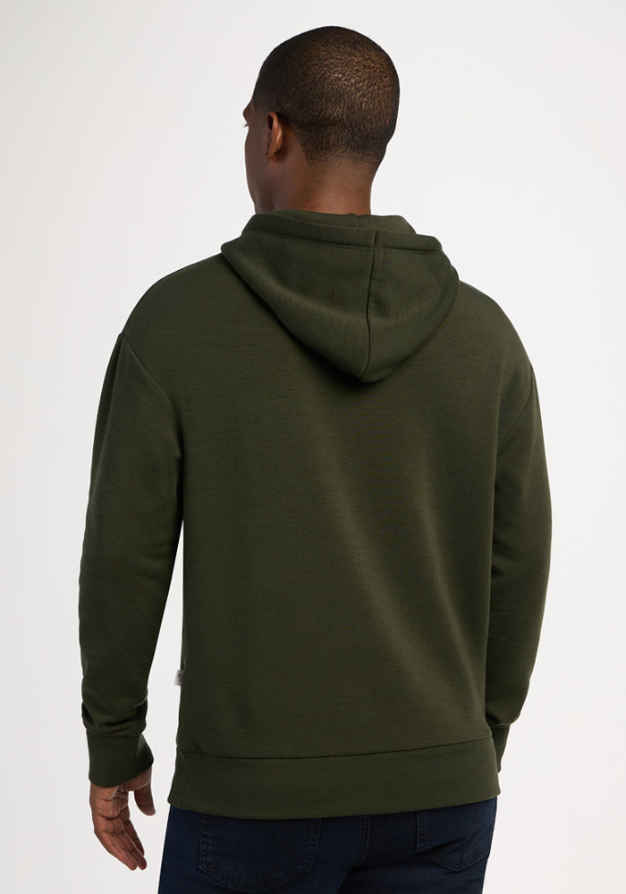 A person in a Woolx Watson Pullover - Duffel Bag and dark jeans, shown from the back against a plain background.