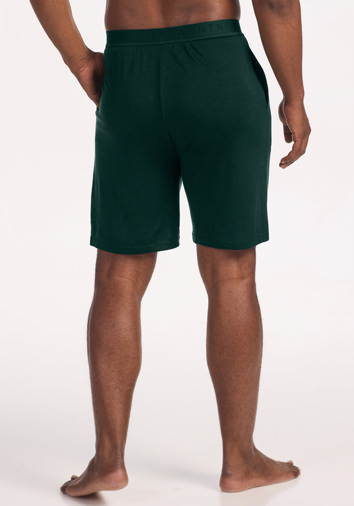 Rear view of a person wearing dark green Archer Lounge Shorts - Deep Pine made of Merino wool with an elastic waistband.