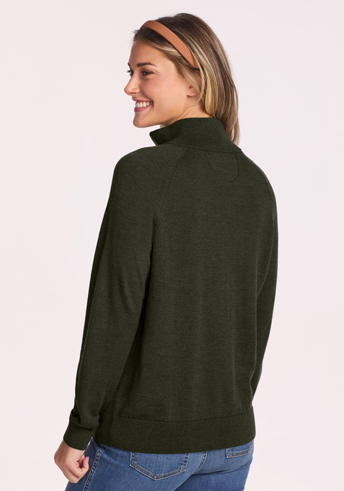 Woman with long hair in a headband wears Woolx Collins Half Zip Sweater - Duffel Bag and blue jeans, facing away.