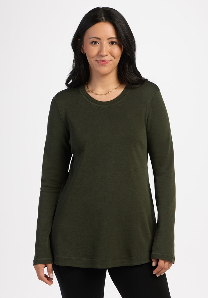 Woman in Woolx Blair Tunic - Duffel Bag and black pants, ideal for travel, stands against a plain white background. 