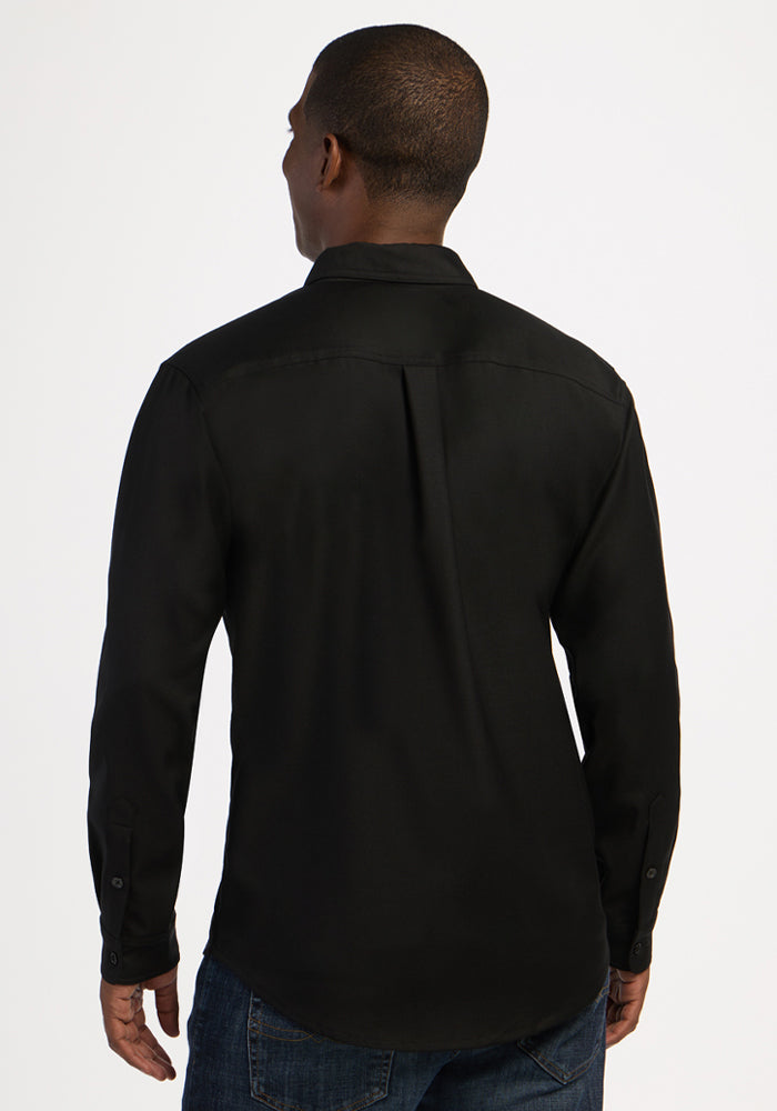 Man wears Woolx Nash Button Up - Black with jeans, facing away from the camera against a white background.