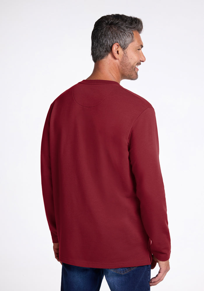 Man with short dark hair in Woolx Jackson Henley - Pinot Noir and jeans, facing away, smiling.