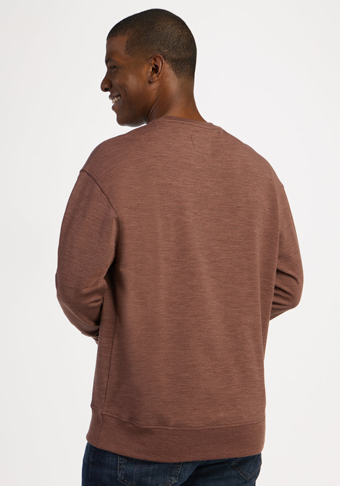 A man viewed from behind, wearing a heavyweight merino Miles Crewneck - Sable Heather sweater.
