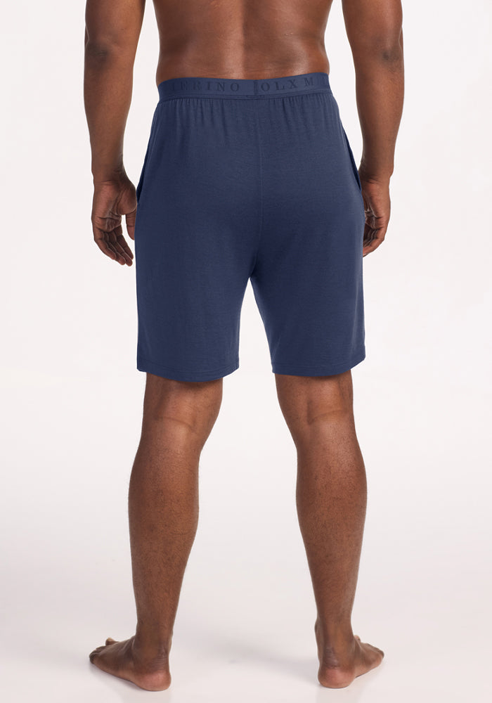 Rear view of a person wearing navy blue Woolx Archer Lounge Shorts - Deep Dive with an elastic waistband.