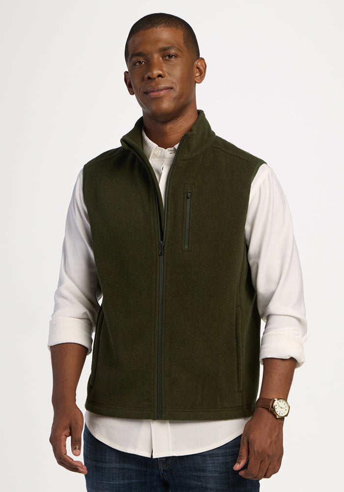 A man wearing a Woolx Everest Vest - Duffel Bag over a white button-down shirt. | Trell is 6’2”, wearing a size M