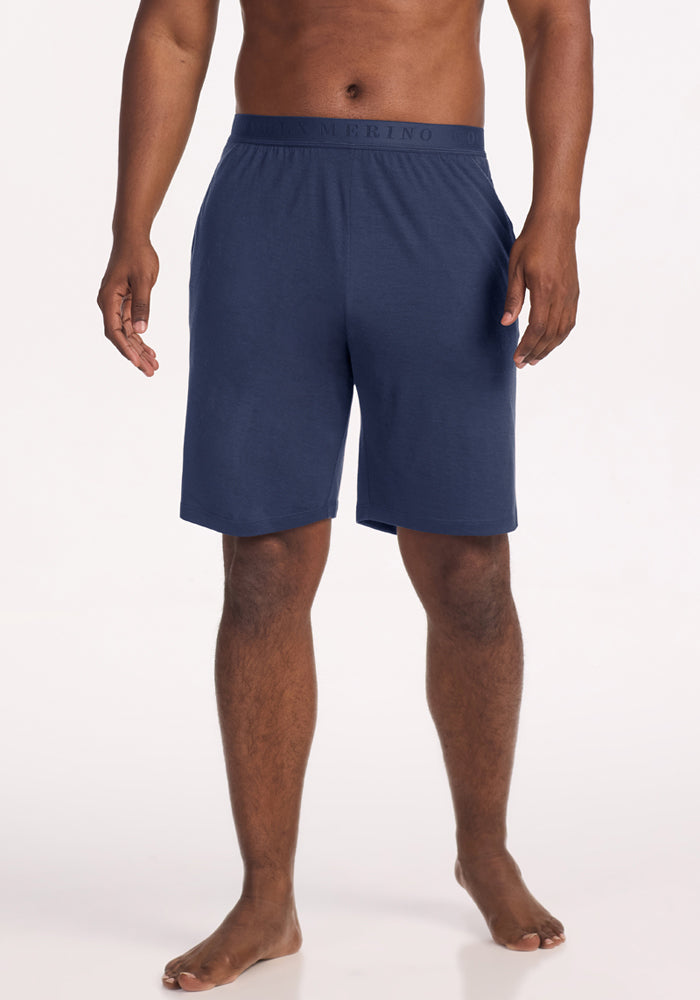 A man wears navy blue Archer Lounge Shorts - Deep Dive Merino wool lounge shorts with an elastic waistband. 