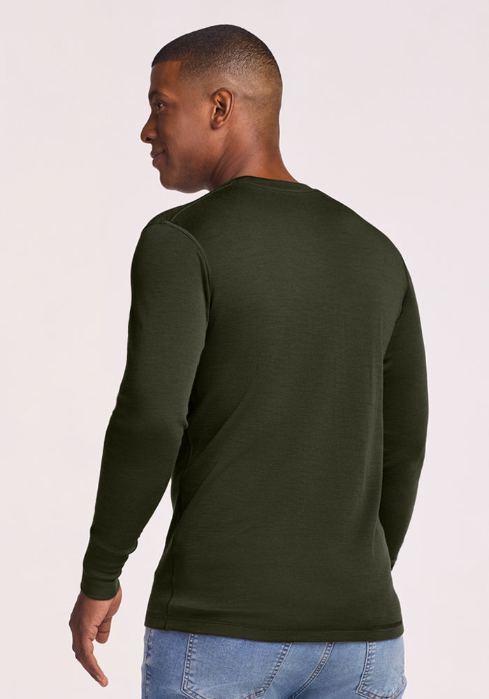 Man in Woolx Explorer Base Layer - Duffel Bag, long-sleeve shirt and blue jeans, standing with back to camera.