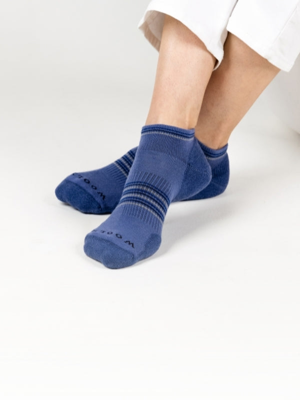 Person wearing blue socks with a white background