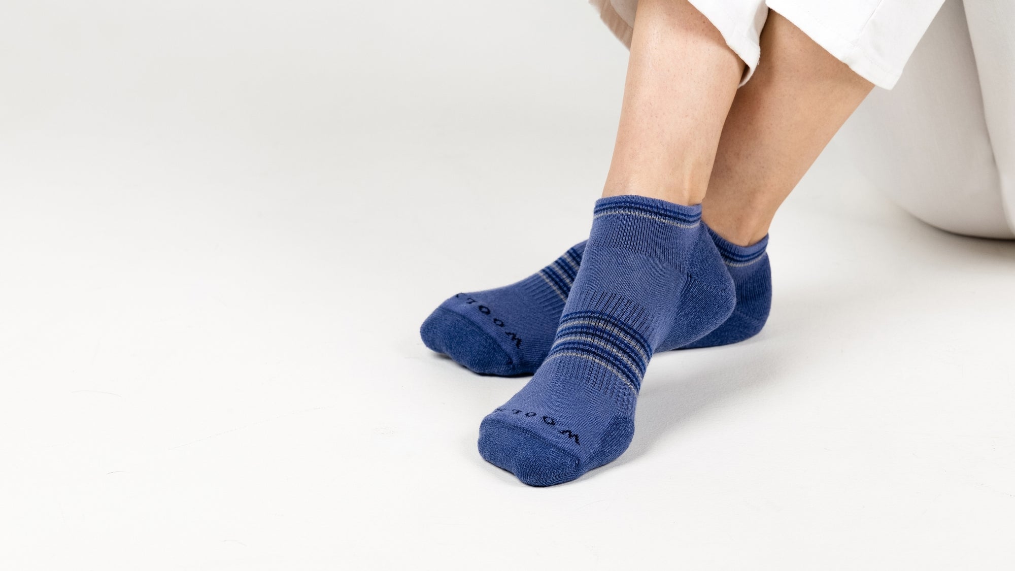 Blue socks worn by a person on a white background