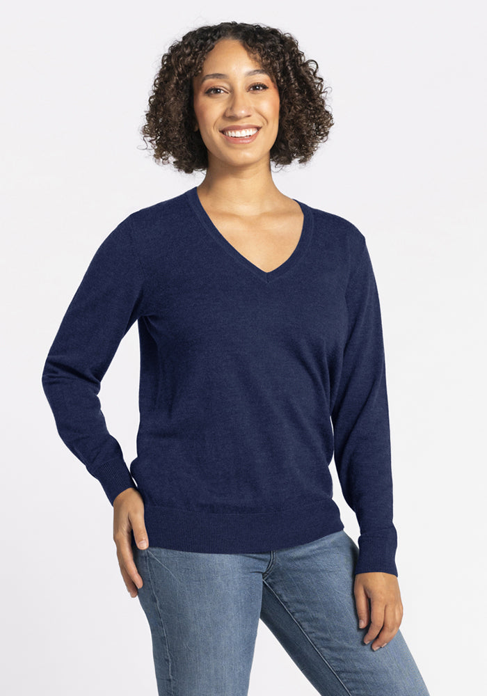 Smiling person in Woolx Francesca Sweater - Ocean Cavern and blue jeans, standing against a plain light background. | Tori is 5'7", wearing a size S