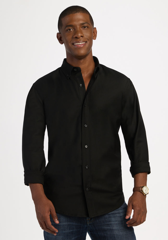 Smiling man in Woolx Nash Button Up - Black and blue jeans stands against a plain light background. 