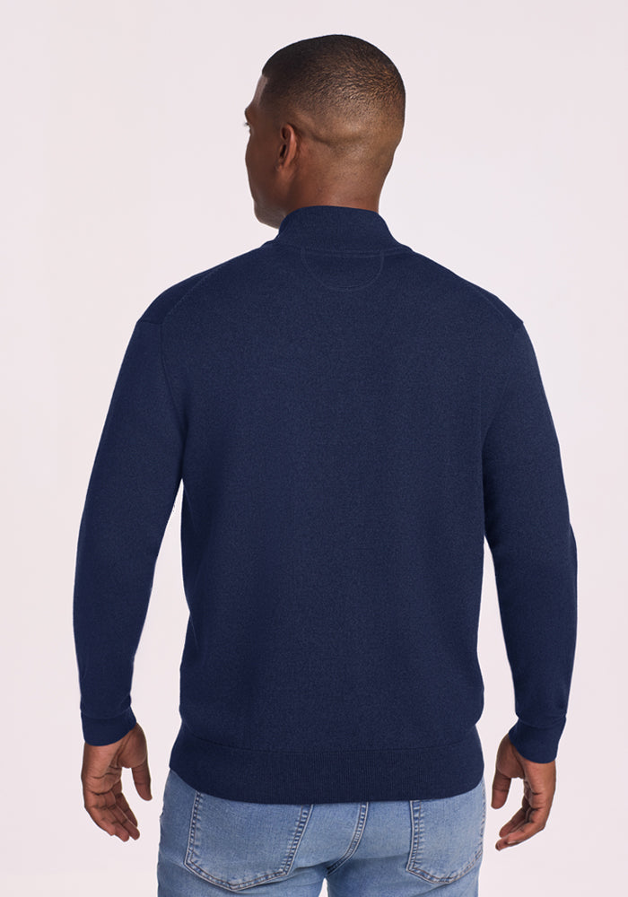 Man facing away in Woolx Enzo Quarter Zip - Ocean Cavern and light blue jeans, perfect midweight layering piece.