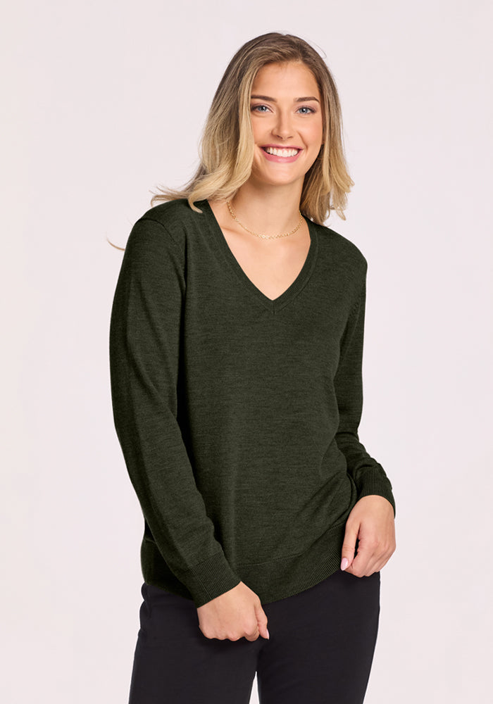 Woman smiling, wearing the Woolx Francesca Sweater in Duffel Bag and black pants against a plain light background. | Ariana is 5'11", wearing a size XL