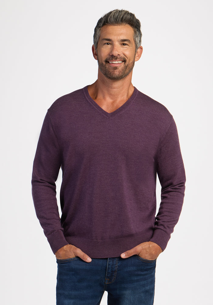 Smiling man in Woolx Vincenzo Sweater—Purple Iris—and jeans, hands in pockets: a men’s wardrobe essential look. | Matthew is 6’, wearing a size L