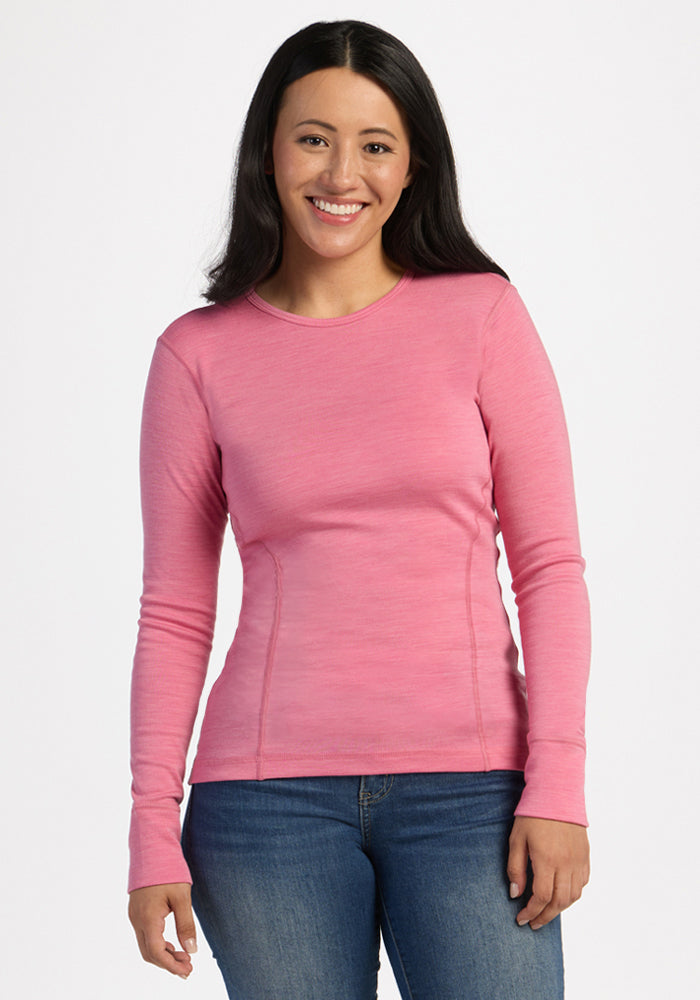 Woman in Woolx Hannah Long Sleeve Top - Pinky Promise and jeans, smiling against a plain white background. 