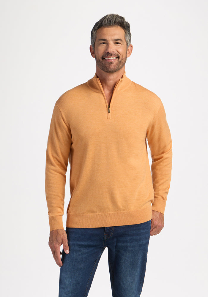 Man in a Woolx Enzo Quarter Zip - Butterscotch and blue jeans smiling against a plain white background. 