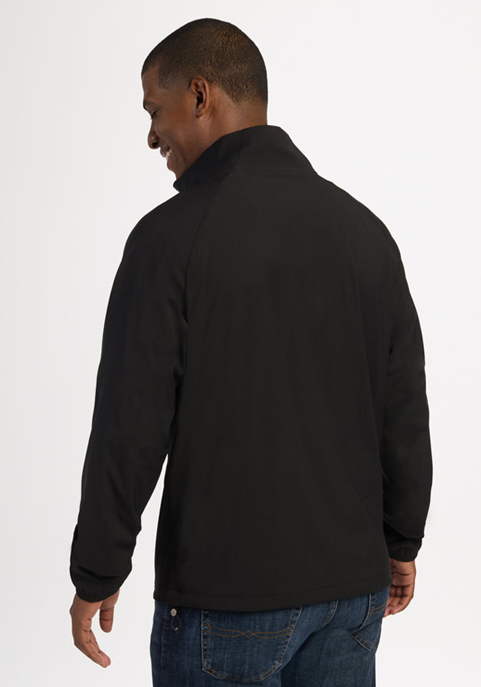 Man in Woolx Dominator Windbreaker - Black and blue jeans faces away, head turned left, on white background.