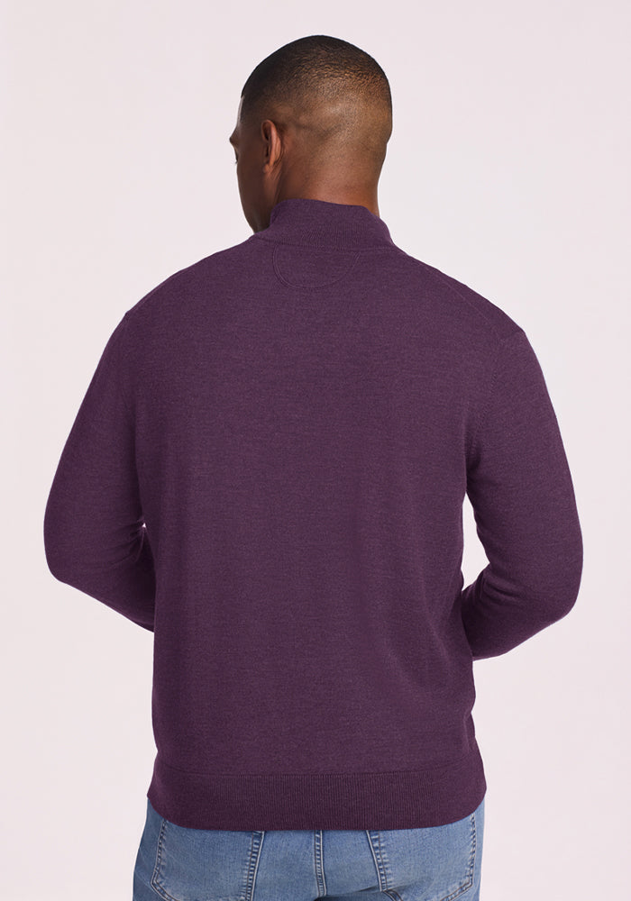 Man facing away in a Woolx Enzo Quarter Zip - Purple Iris sweater and blue jeans, against a light background.