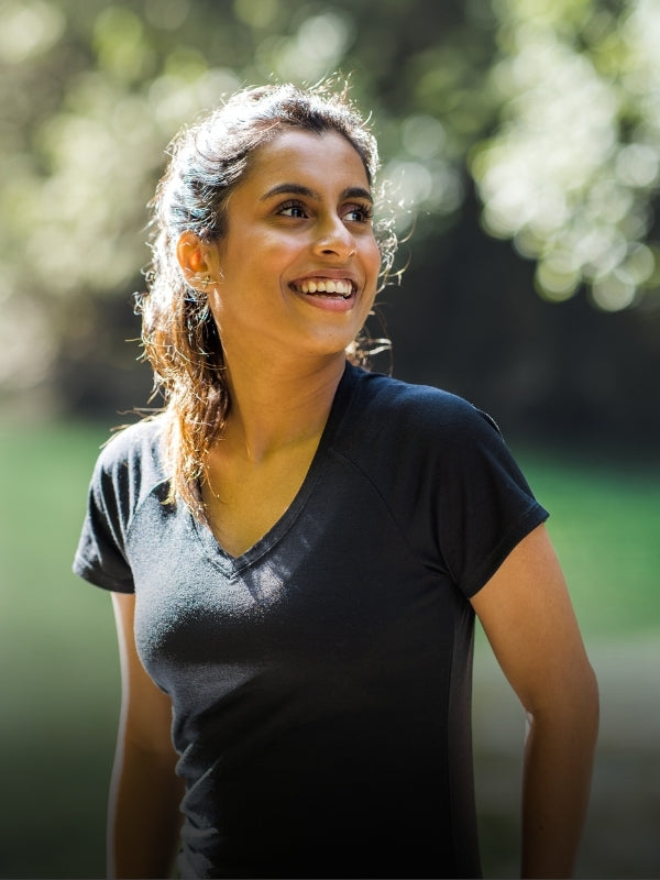 Woman wearing black mia tee standing outdoors mobile size