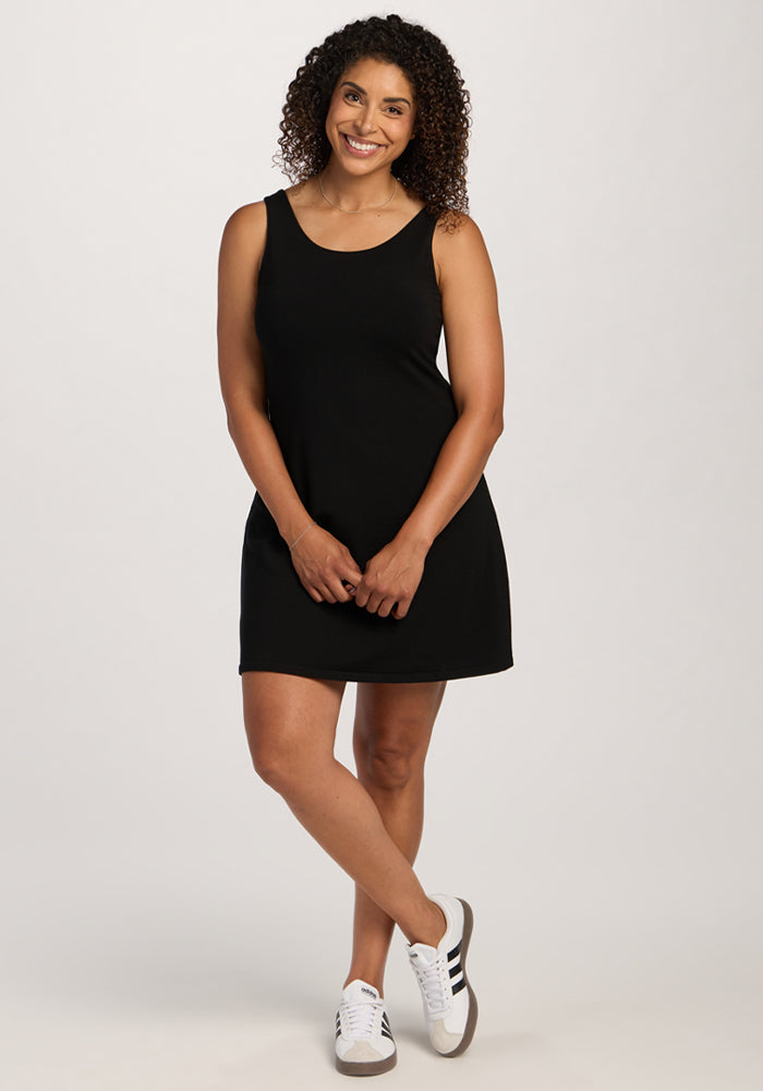 Woman with curly hair in Woolx Adrienne Active Dress - Black and white sneakers, smiling against a plain background.