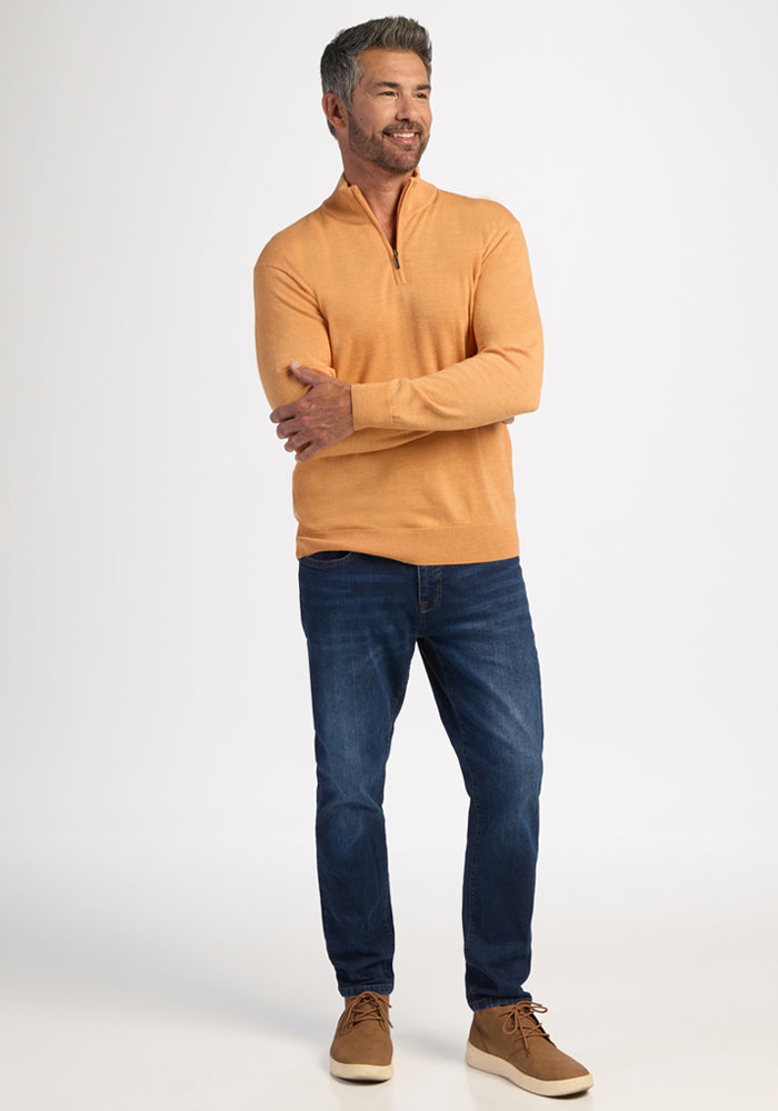 Man in a Woolx Enzo Quarter Zip - Butterscotch, blue jeans, and tan shoes smiles against a white background.