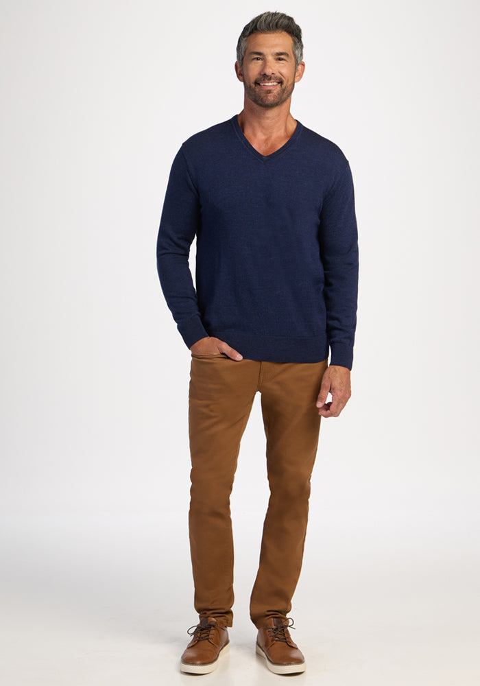 Smiling man in a Woolx Vincenzo Sweater - Ocean Cavern and brown pants stands facing forward against a white background.