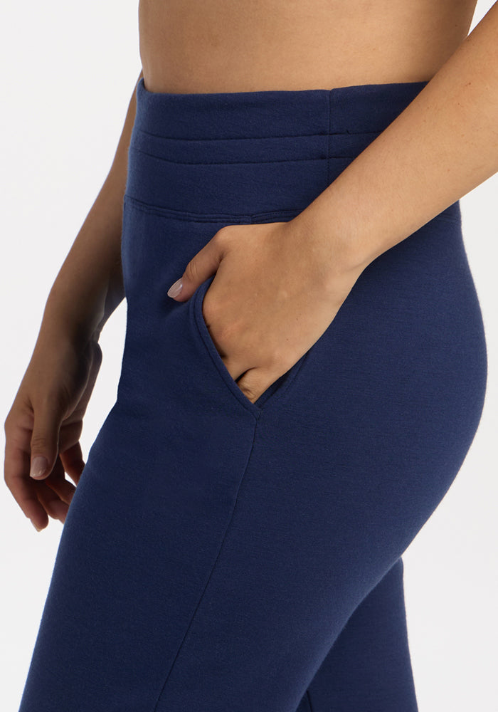 Model wears Woolx Willa Joggers in Ocean Cavern, hand in pocket, waist to mid-thigh view on white background.
