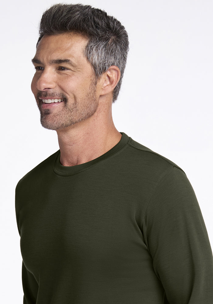 Smiling man with short gray hair wears Woolx Easton Crew Neck Shirt in Duffel Bag, facing slightly left.
