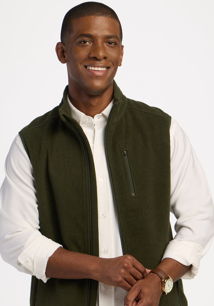 A smiling man wearing a Duffel Bag Everest Vest over a white button-down shirt.