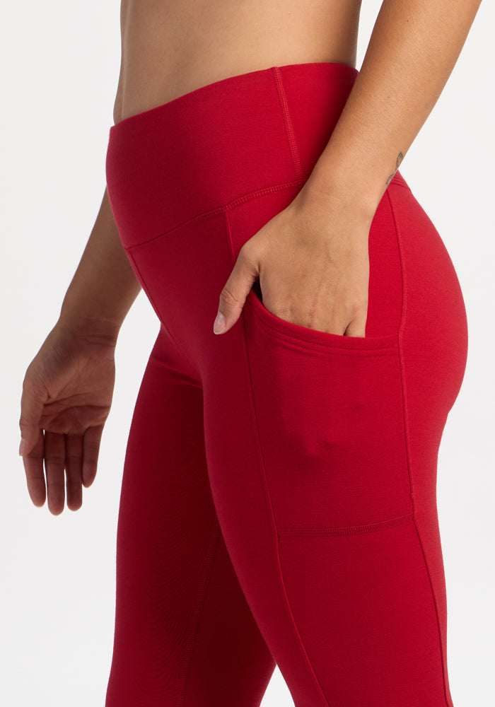 Model in Woolx Piper Pocket Leggings - Maraschino Cherry, shown mid-torso to thigh, hand in side pocket.