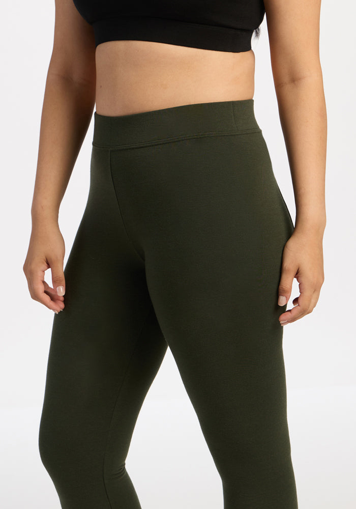 Woman in Woolx Stella Leggings - Duffel Bag and a black crop top stands against a plain white background.