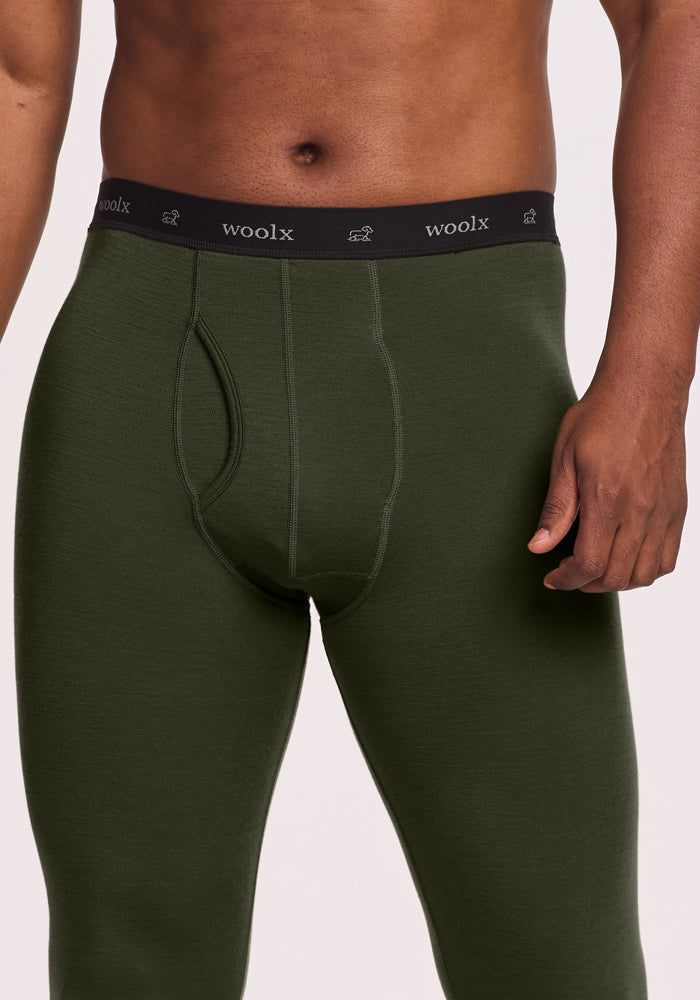 Man in Woolx Backcountry Leggings in Duffel Bag green, black “woolx” waistband, cropped at the chest.