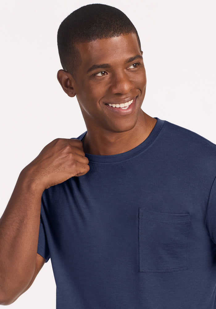 A smiling man wears a dark blue Woolx Finn Top - Deep Dive lounge shirt with a chest pocket.