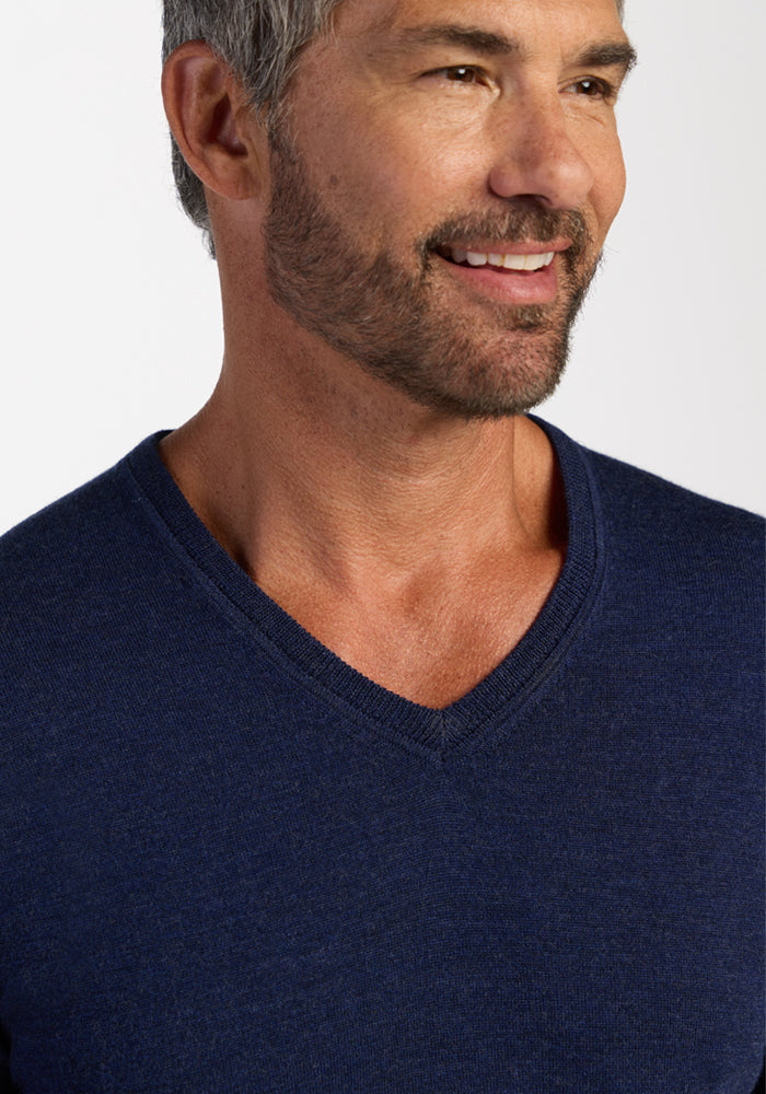 Smiling man with salt-and-pepper hair wears Woolx’s Vincenzo Sweater in Ocean Cavern—a timeless wardrobe staple.