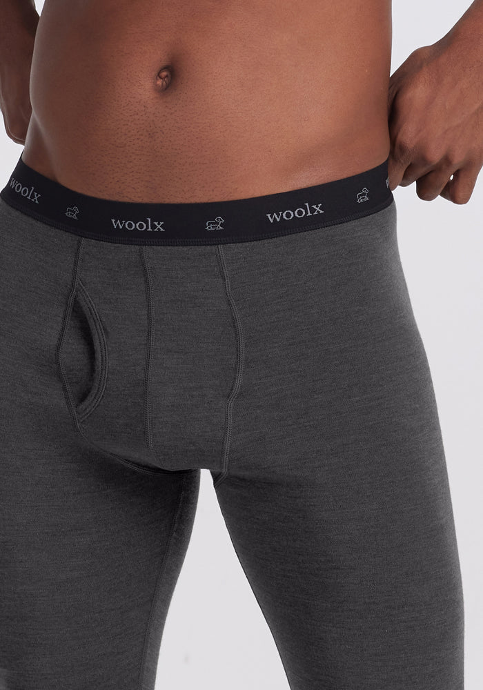 Man wearing Woolx Backcountry Leggings in Cinder Melange, black waistband, shown waist to mid-thigh.