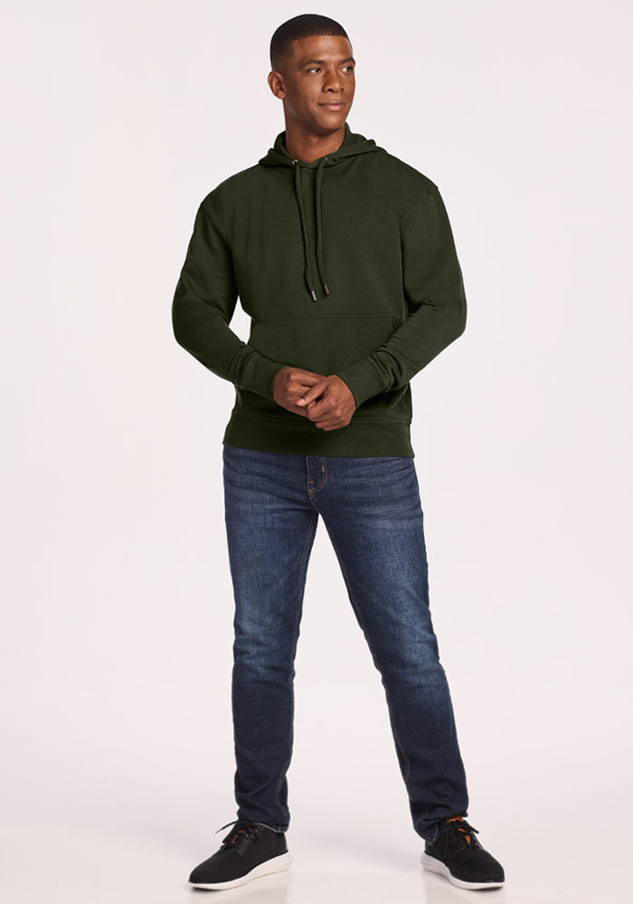 Man wears Woolx Chase Hoodie - Duffel Bag and blue jeans, standing against a white background, looking to the side.