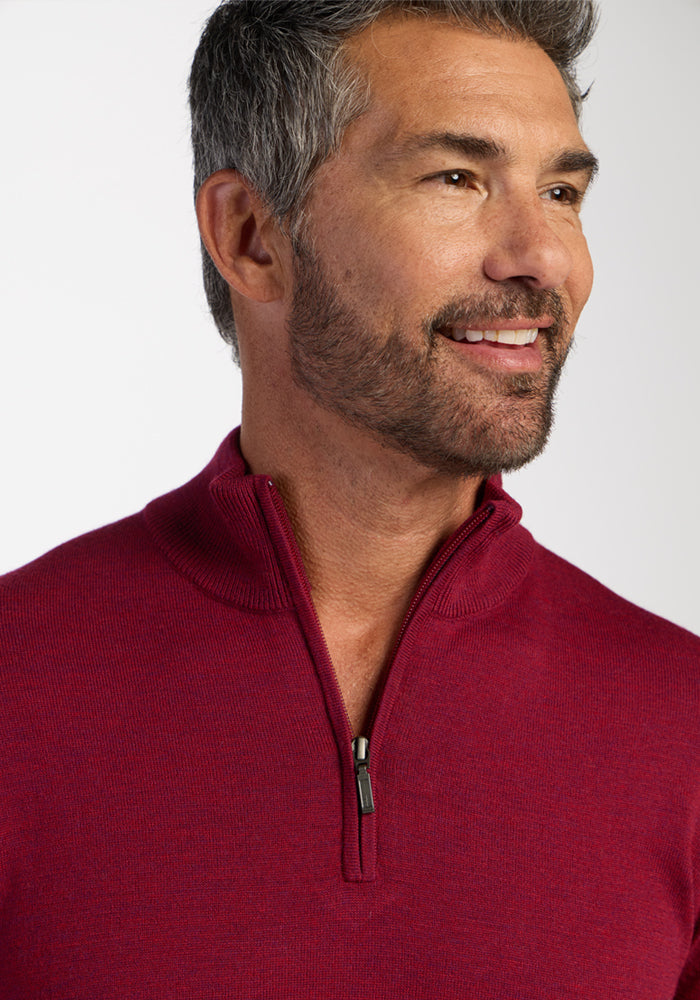 Smiling man in a Woolx Enzo Quarter Zip - Beet Red, with gray hair and beard, looking to the side.