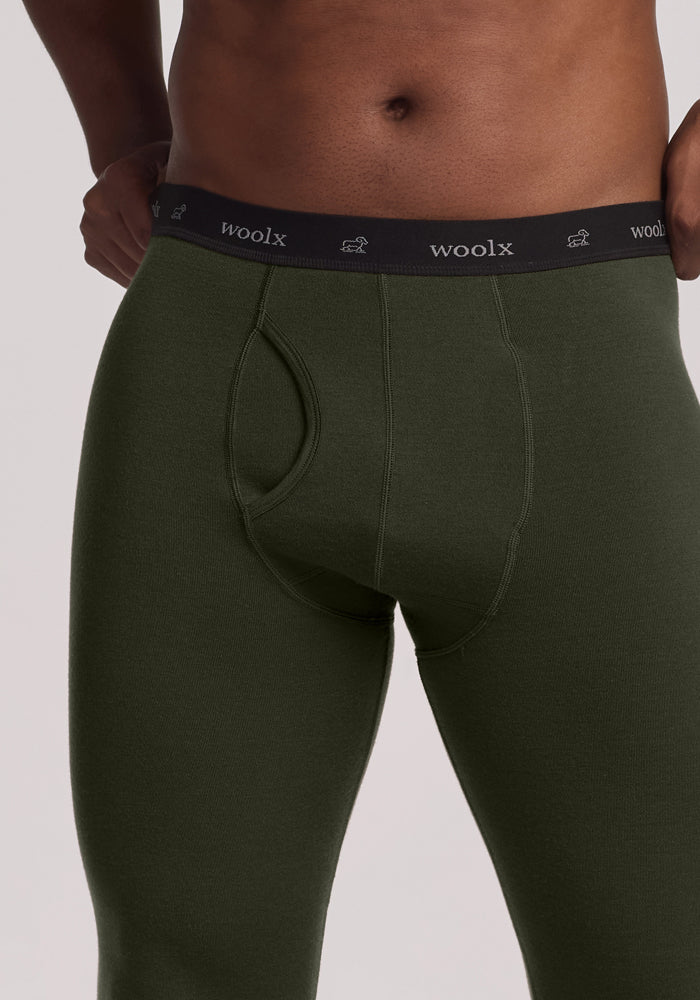 Man wearing Woolx Arctic Leggings in Duffel Bag color, black “woolx” waistband, hands on hips.