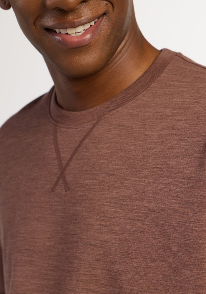 A person wearing a Sable Heather Woolx Miles Crewneck, a heavyweight merino sweater with a V-stitch detail at the collar.