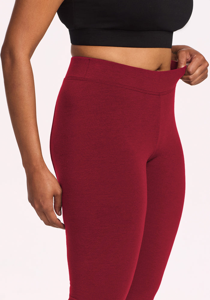 Model wears Woolx Stella Leggings - Pinot Noir, flaunting the high-waisted fit with a black crop top.