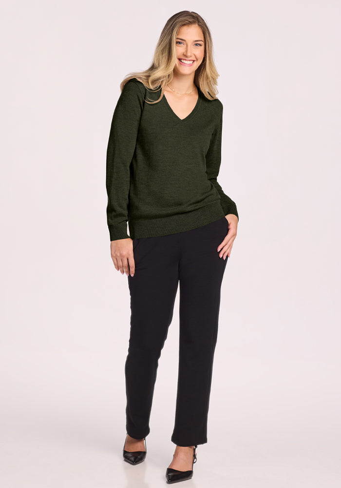 Woman in Woolx Francesca Sweater - Duffel Bag, smiles in black pants against a light background.