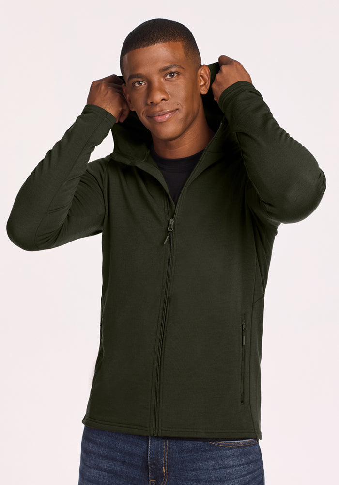 Man in Woolx Boulder Hoodie - Duffel Bag, holding hood, wearing jeans, against a plain background.