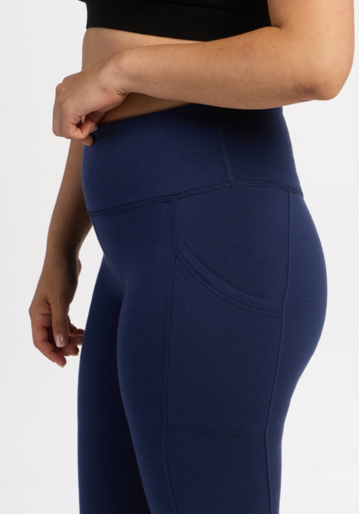 Model wears Woolx Piper Pocket Petite leggings in Ocean Cavern, high-waisted, with side pocket, waist to mid-thigh view.